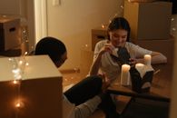一对夫妇在烛光和串灯照亮的移动盒子里享受外卖