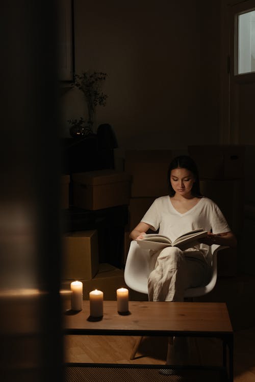 Woman in White Long Sleeve Shirt Sitting on Chair