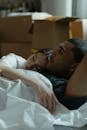 一对夫妇躺在移动的箱子里，在新公寓中拥抱新的开始