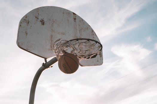 Basketball sinking into hoop against a dramatic blue sky in Ottawa, Canada.
