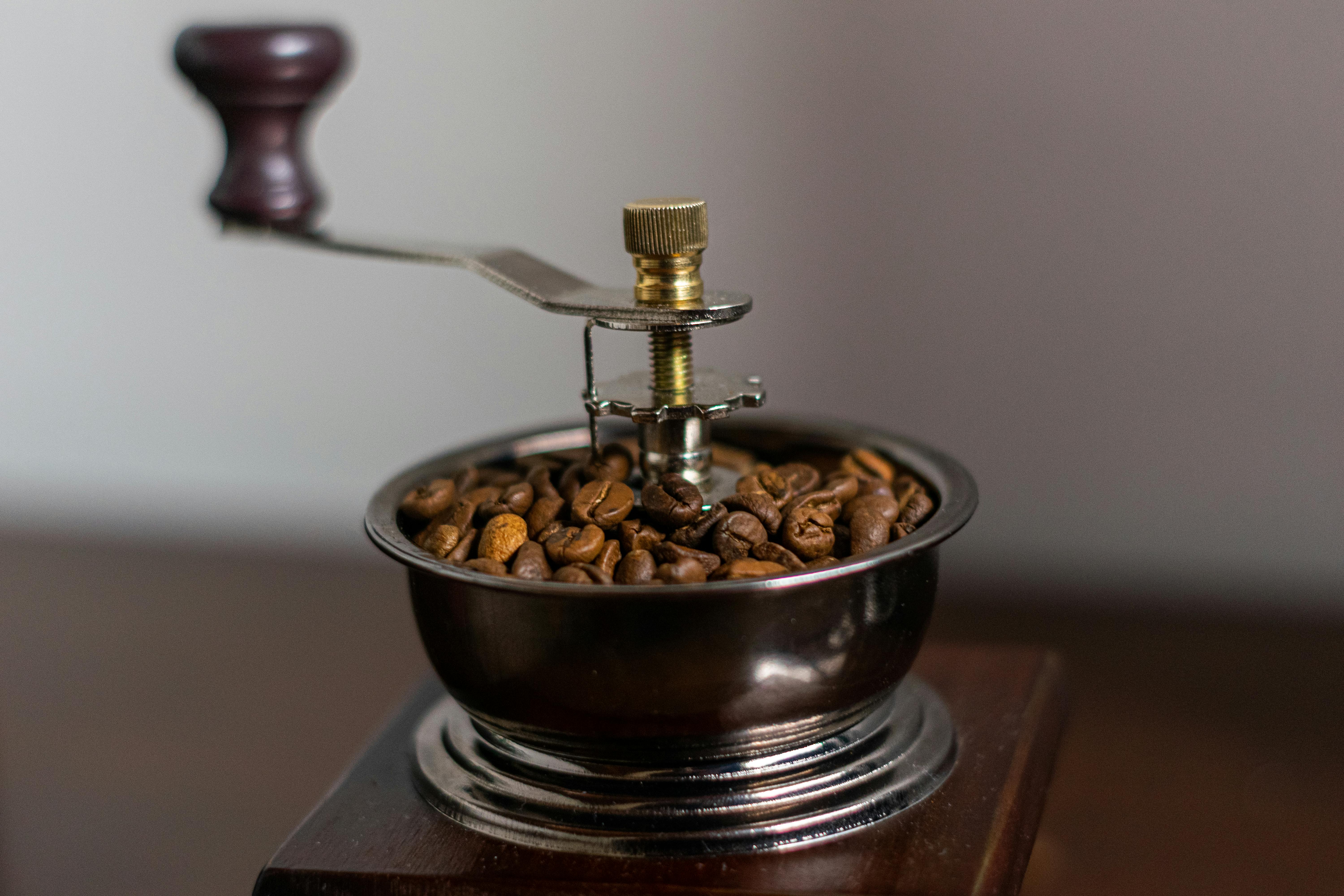 a close-up of a vintage coffee grinder filled with fresh coffee beans.