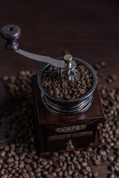 Classic wooden coffee grinder filled with aromatic coffee beans, perfect for vintage kitchen decor.