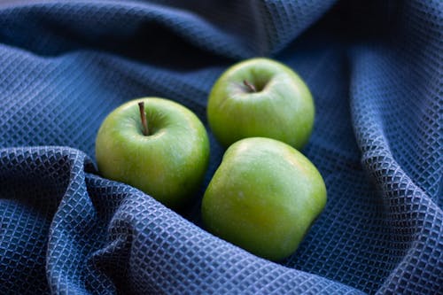 Green Apples on Blue Fabric