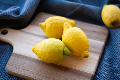 Yellow Lemon Fruit on Brown Wooden Chopping Board