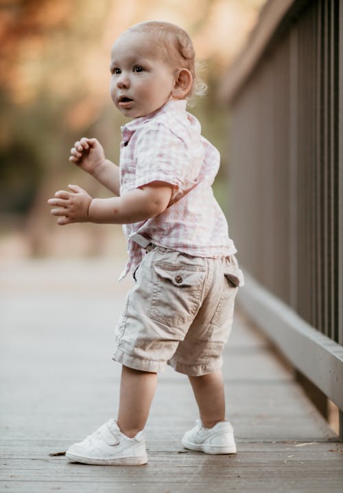 A Little Boy Wearing Pink Shirt and Brown Shorts