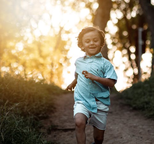 Free Cute Little Boy Running in the Woods Stock Photo