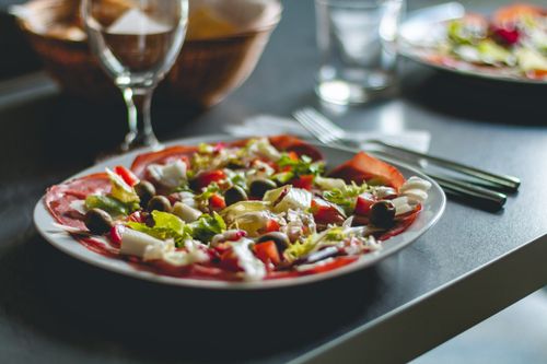 Free Enticing Mediterranean salad featuring olives, cheese, and fresh vegetables on a ceramic plate. Stock Photo