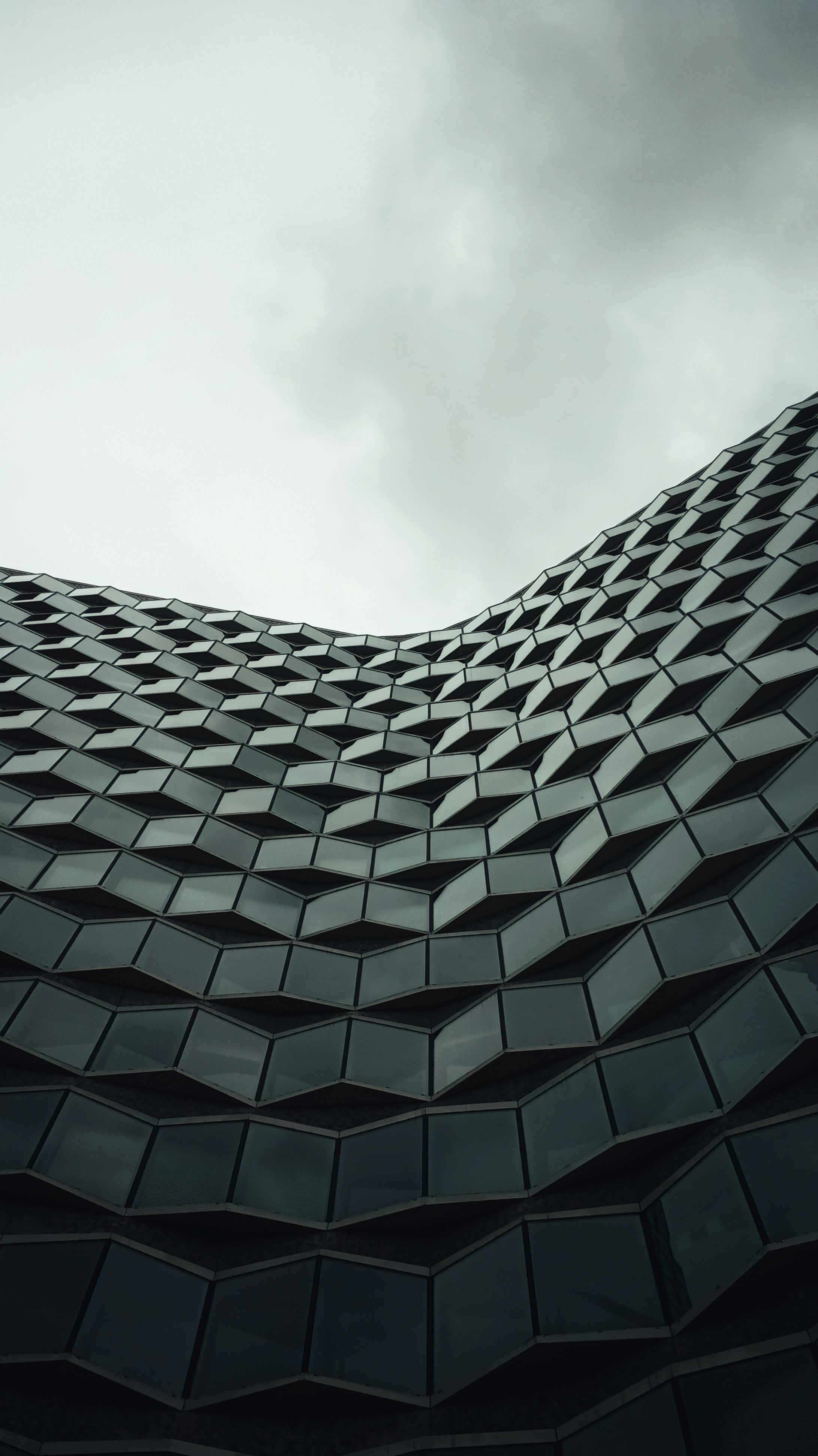 futuristic geometric building against overcast sky