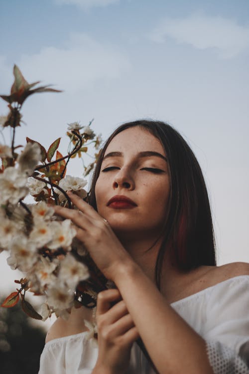 Free Woman in White Off Shoulder Blouse Holding White Flower Stock Photo