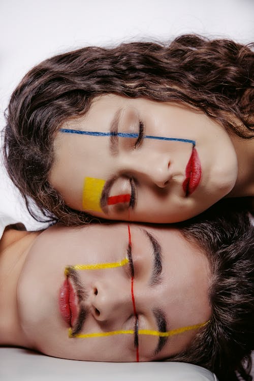 A Couple Heads Together Wearing Art Make-up