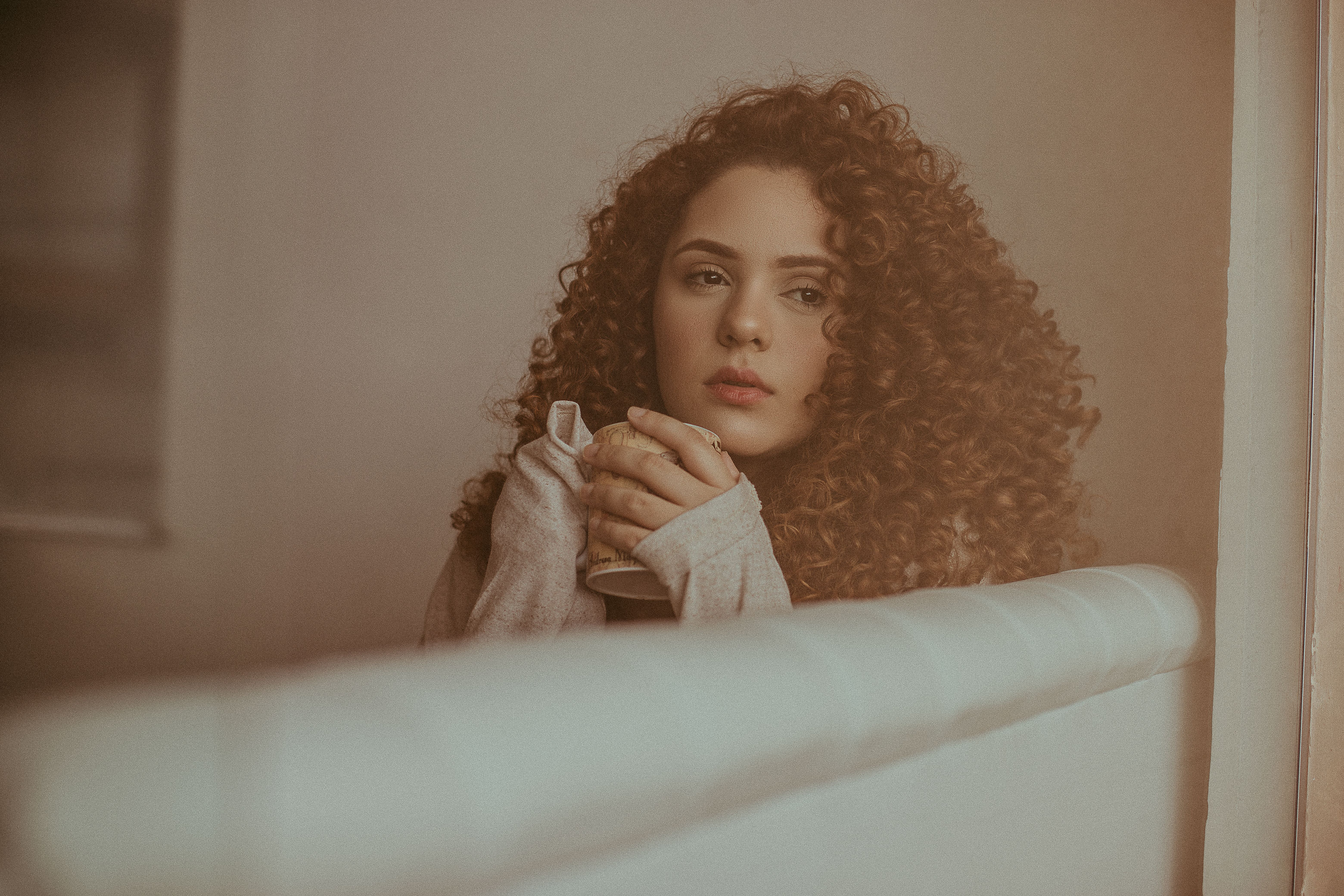 Woman in White Long Sleeve Shirt Sitting on White Sofa · Free Stock Photo
