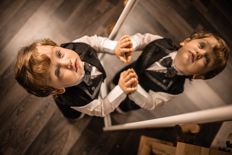 Child Touching Mirror In Bright Room