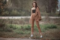 Young stylish woman in trendy outfit standing on roadside