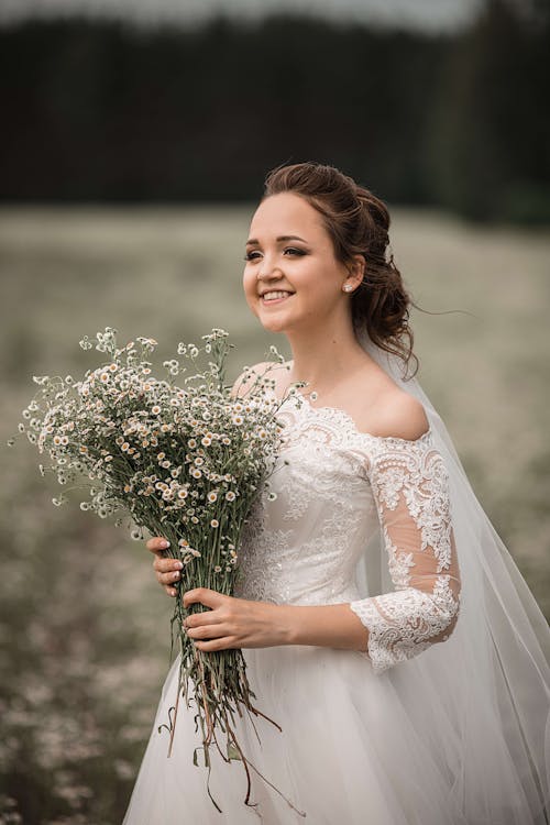Beautiful bride with bouquet of wild flowers · Free Stock Photo
