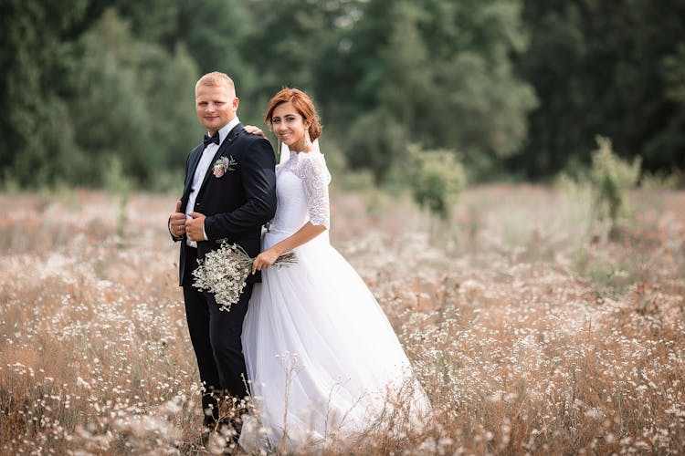 Happy Newlywed Couple In Meadow