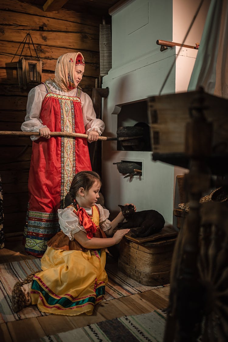 Elderly Woman In Traditional Clothes Near Furnace