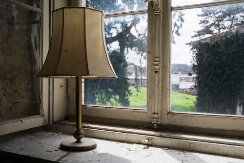 Lamp Standing on a Windowsill of an Old Abandoned House