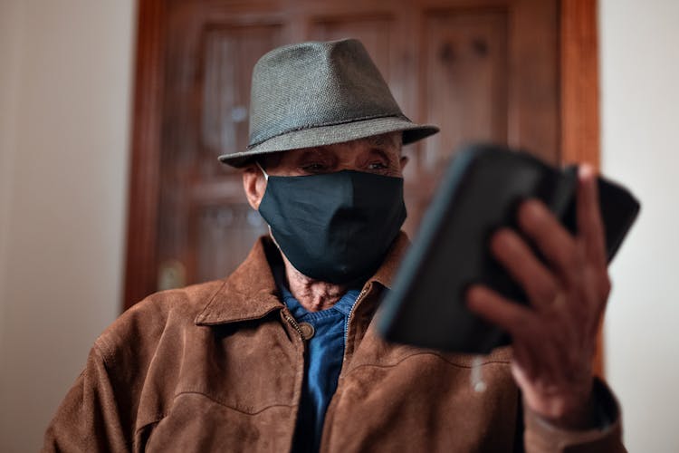 Aged Man In Protective Mask With Smartphone