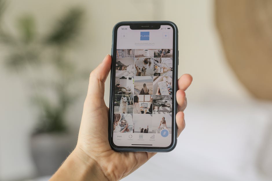 Notion vs Obsidian: Creator Workflow Showdown (2026) Close-up of a hand holding a smartphone displaying a social media app interface, indoors.
