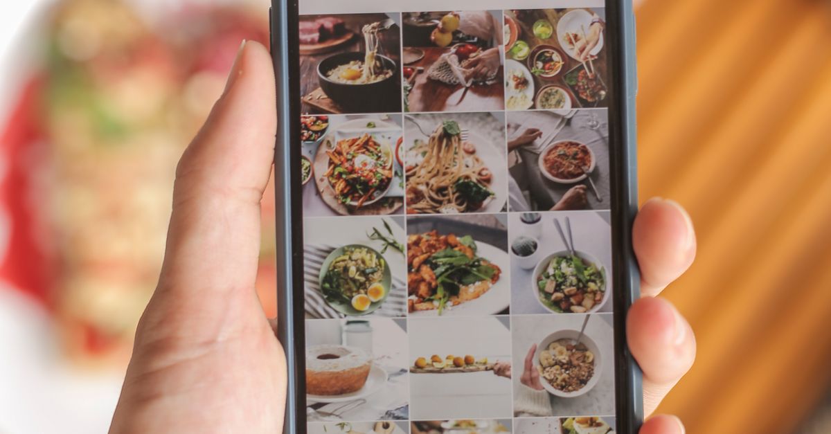 Photo by Plann A hand holding a smartphone displaying a food app interface, showcasing diverse dishes.