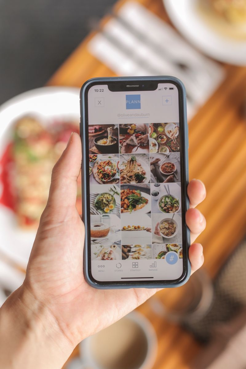 Hand holding a smartphone with a food app interface