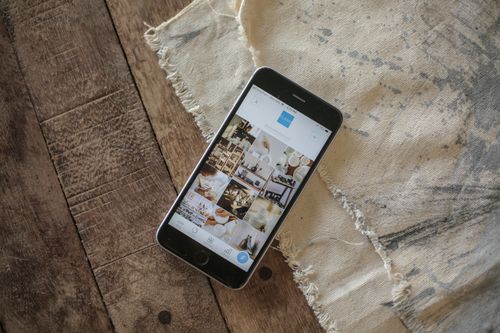 Free Modern smartphone with app open, resting on rustic wooden surface in natural light. Stock Photo