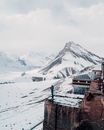 白雪皑皑的露台上，一个孤独的人影正俯瞰着雄伟的冬季山脉