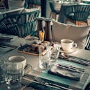 From above of restaurant table set with glassware and silverware before lunch time