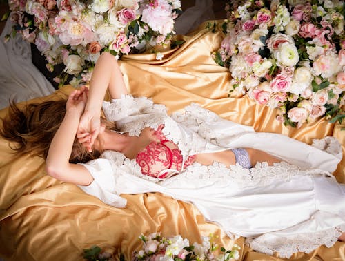 Woman in White Dress Lying on Bed With Pink Floral Brassier