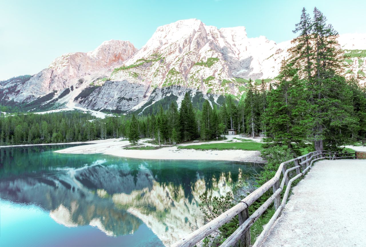 stunning view of an alpine lake with clear reflections of snow capped