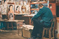Man Sitting in a Room Full of Paintings