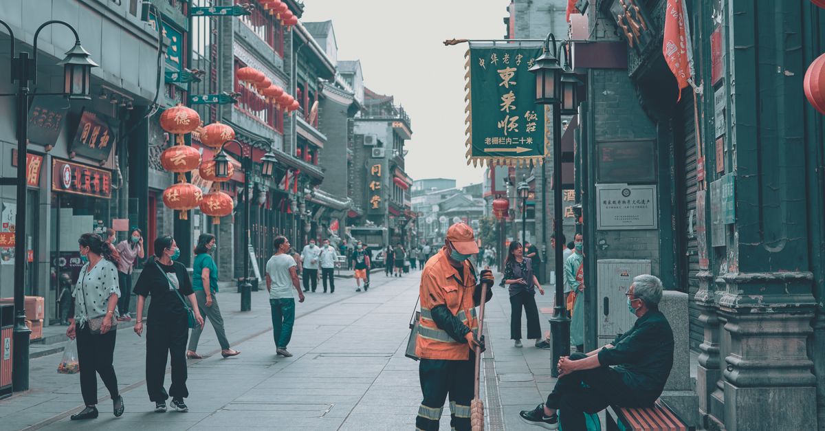 remote worker laptop on balcony overlooking bustling Asian street market