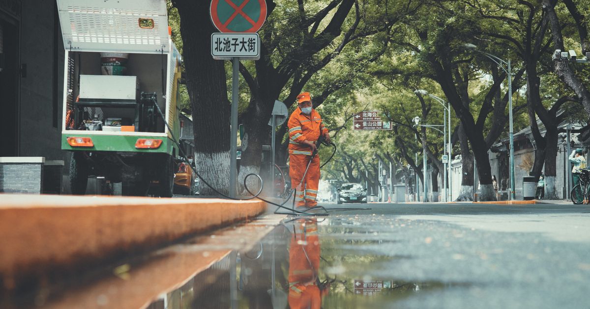 Professionnel du nettoyage urbain utilisant un pulvérisateur haute pression