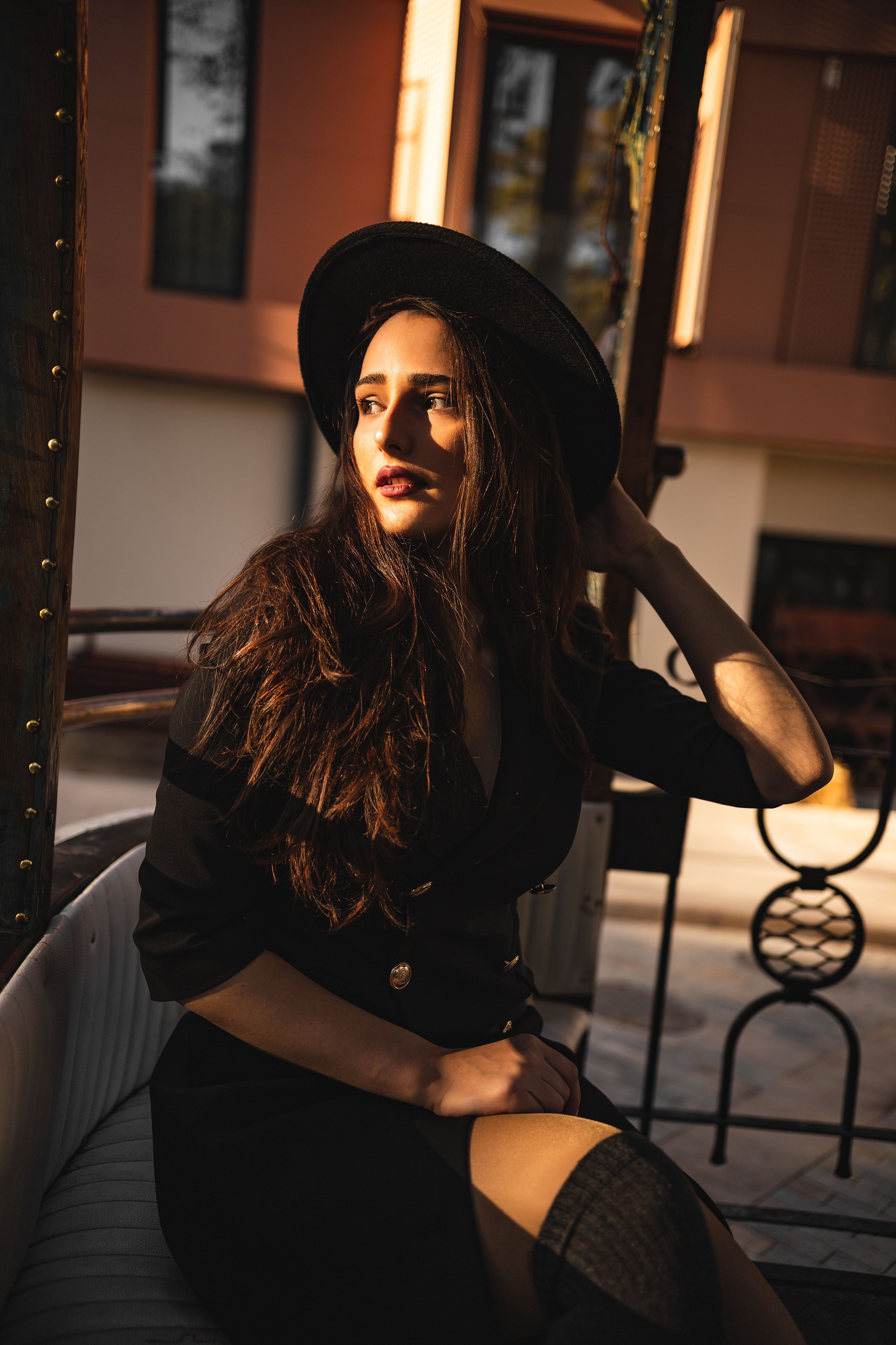 Woman in Black Coat and Black Hat Sitting on Chair · Free Stock Photo