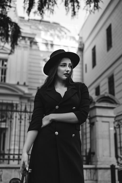 A Woman in Black Coat and Hat in Grayscale Photography