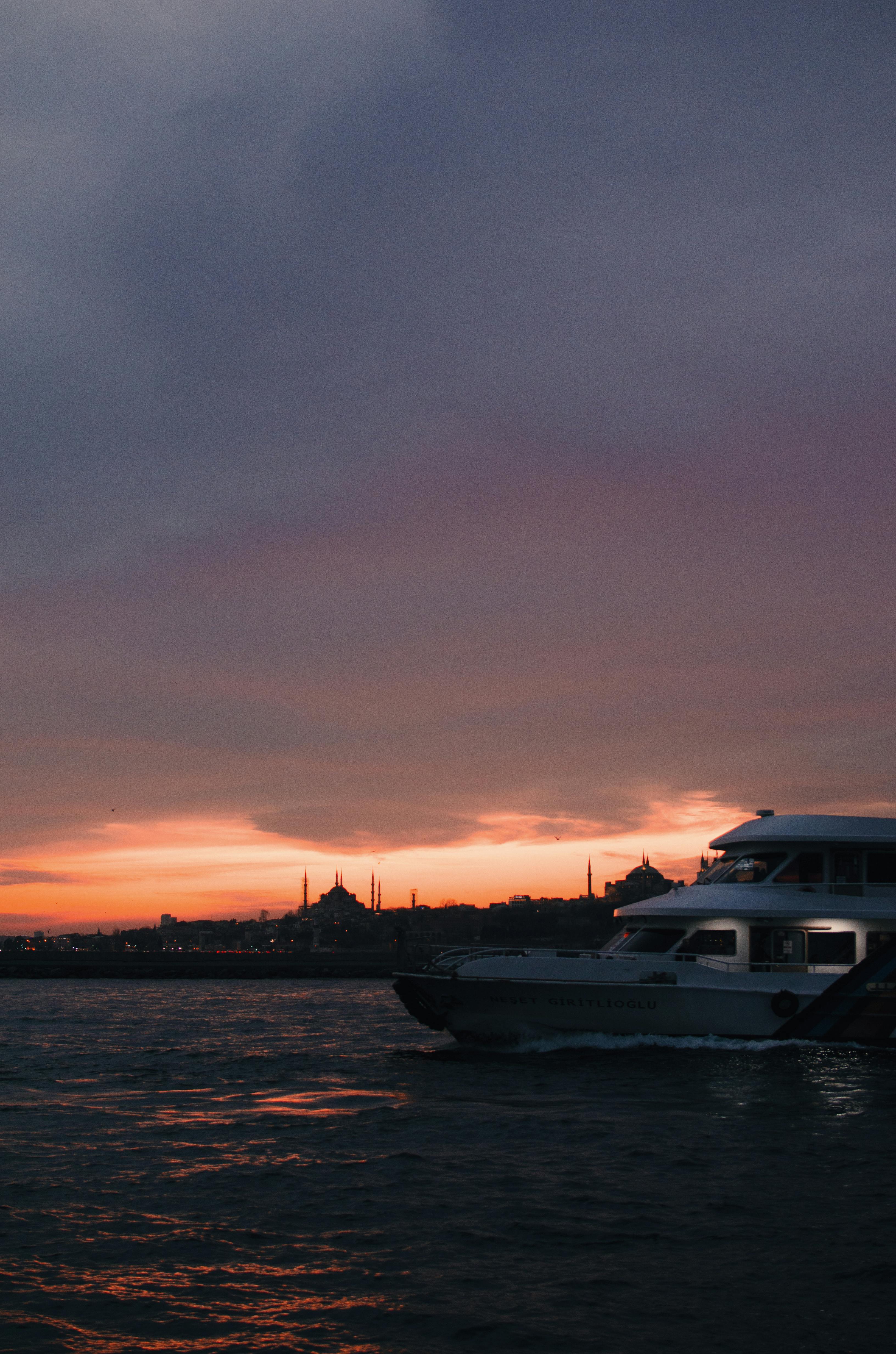 Yacht on wavy sea under sky at sunset · Free Stock Photo