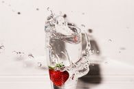 Clear Drinking Glass With Strawberry and Overflowing Water