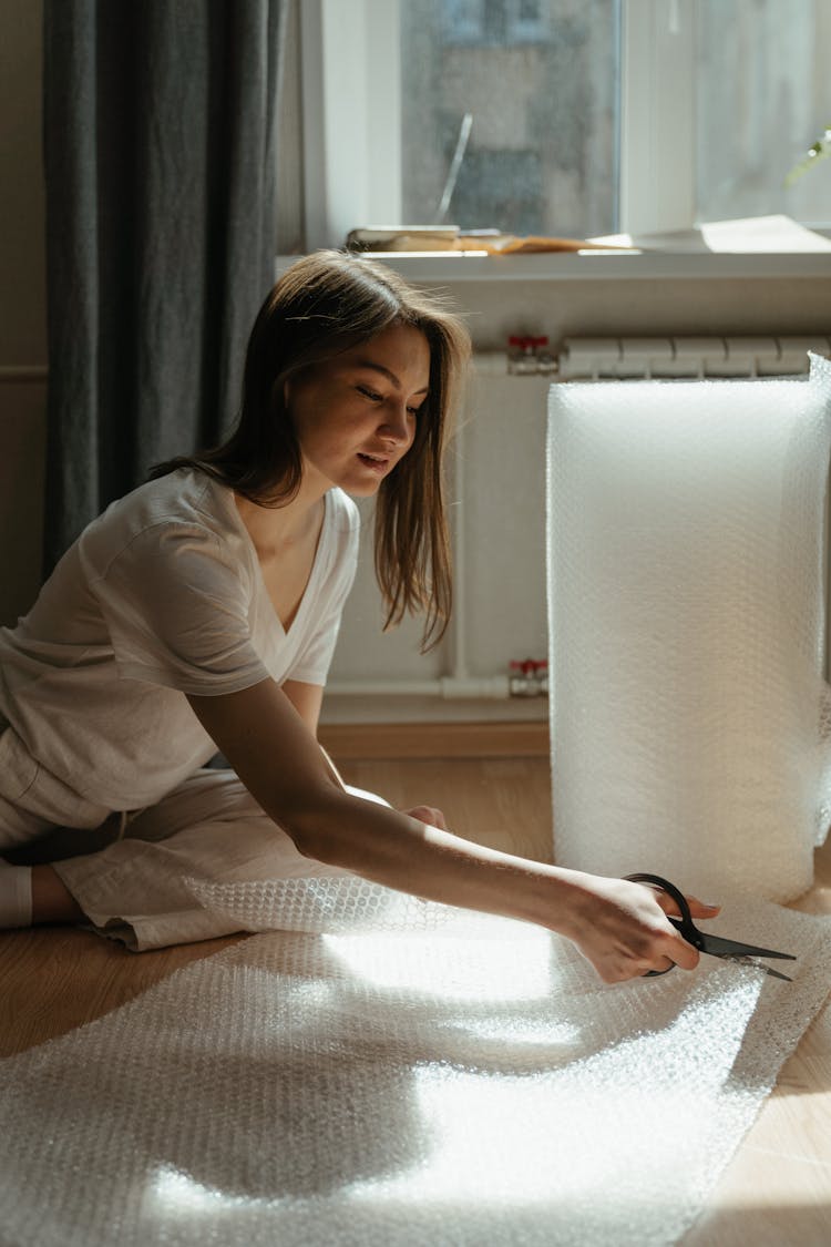 Woman In White Crew Neck T-shirt Sitting On White Textile