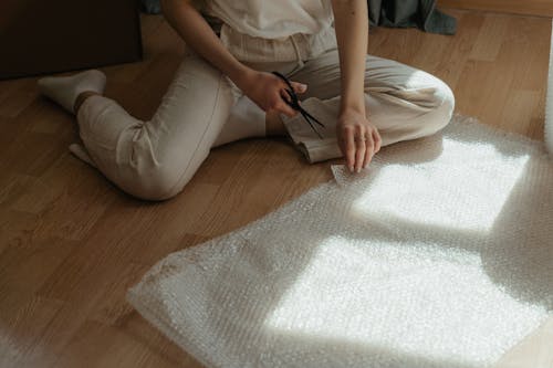 Woman in White Pants Sitting on Bed