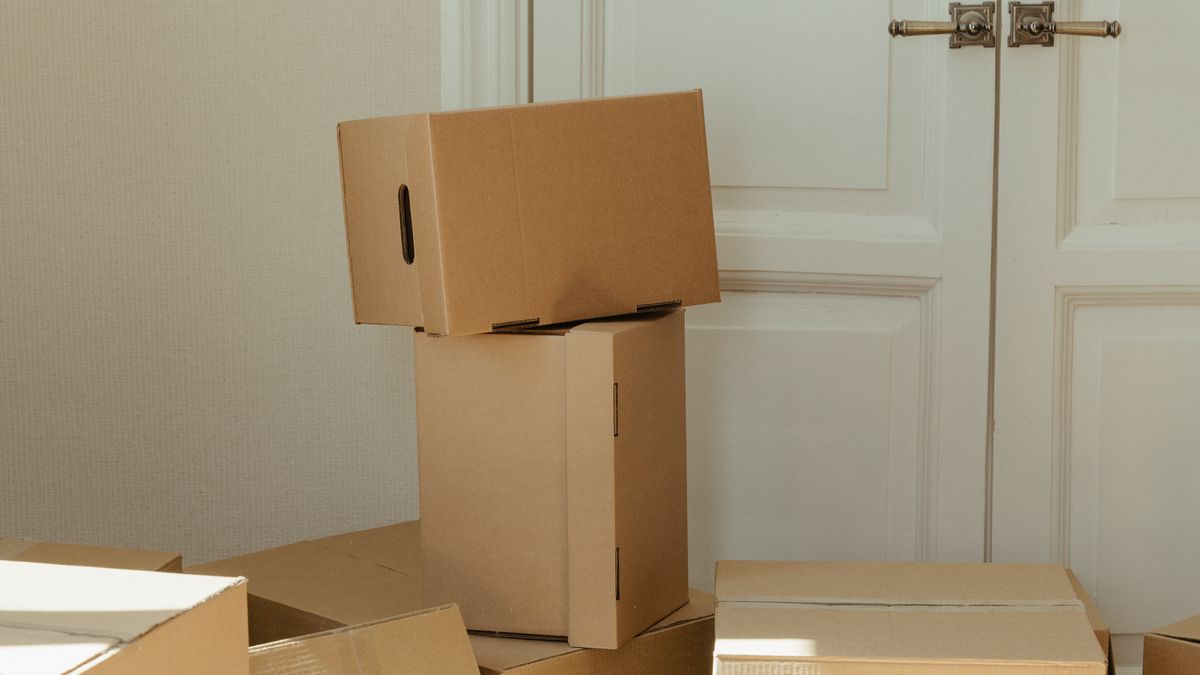 Cardboard boxes stacked by a white door, ready for a move