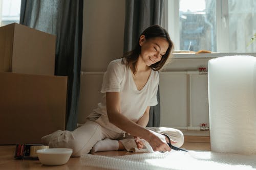 Woman in White Crew Neck T-shirt Sitting on Bed