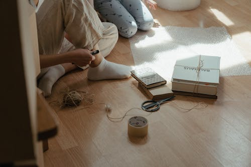 Free Person in White Pants and White Socks Sitting on Floor Stock Photo