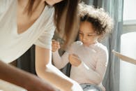 一个卷发的黑人孩子在阳光明媚的房间里，正享受着和母亲在一起的时光