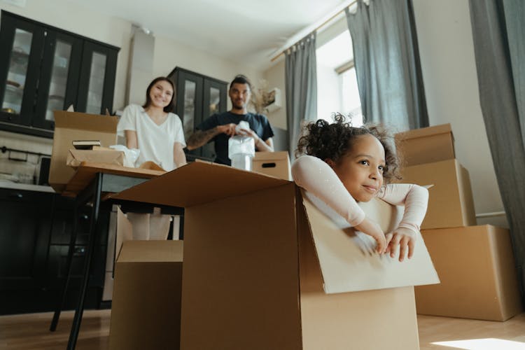 Little Girl Playing In A Box