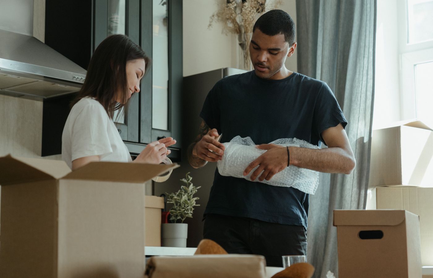 A young couple unpacking boxes together, settling into their new apartment.