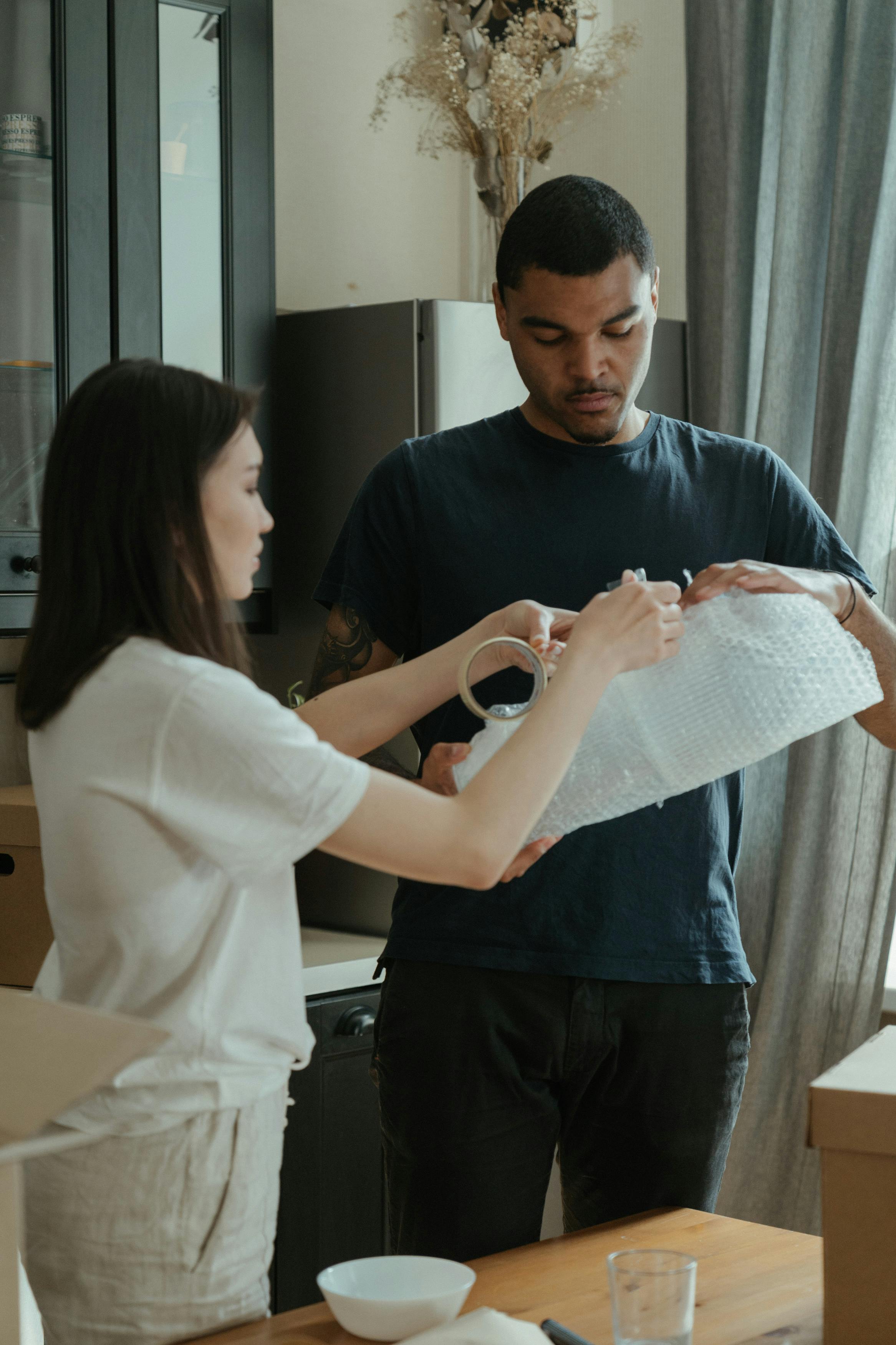 man in black crew neck t shirt holding white tissue paper