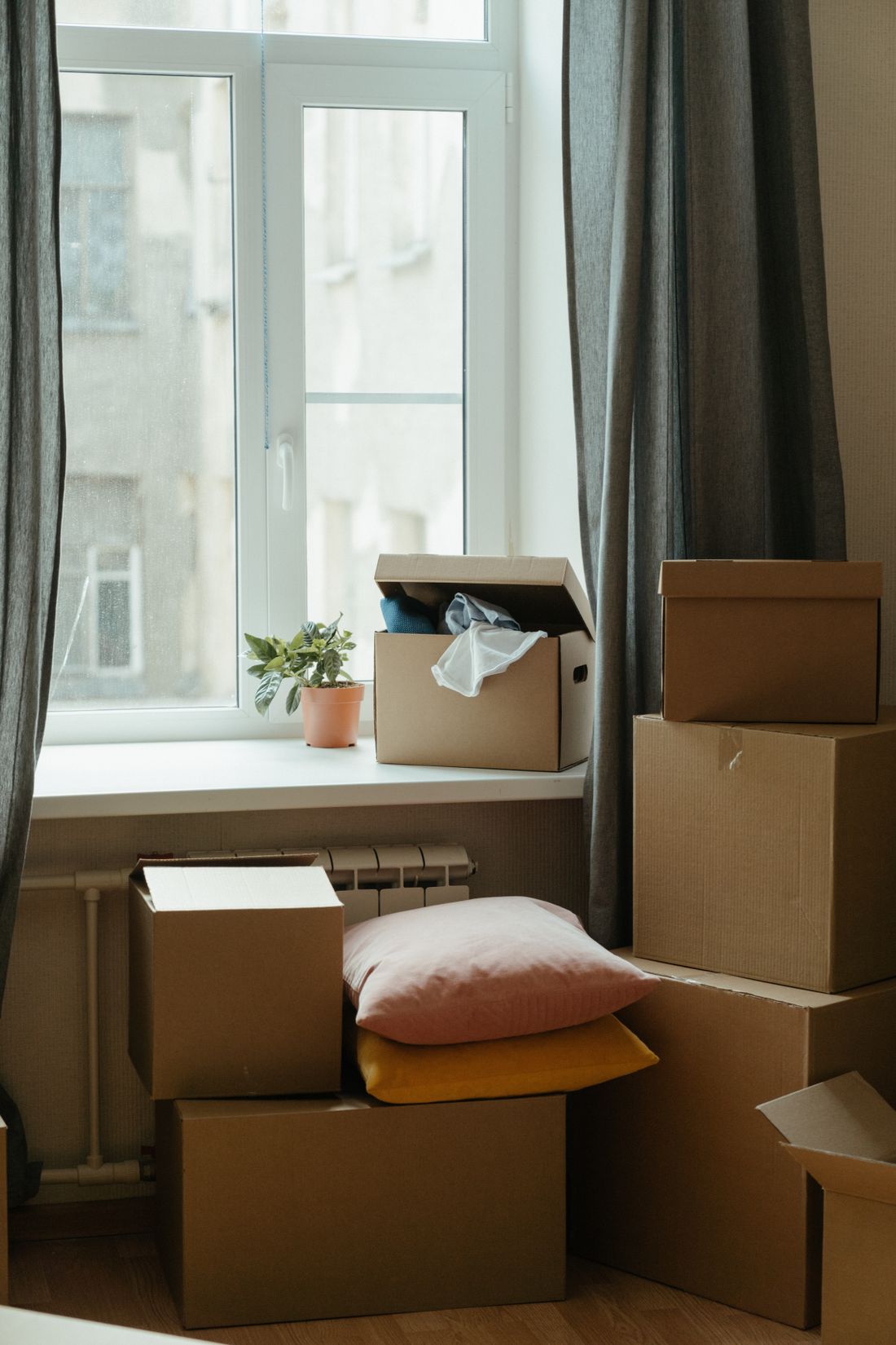 Umzugskartons in einem sonnigen Raum am Fenster