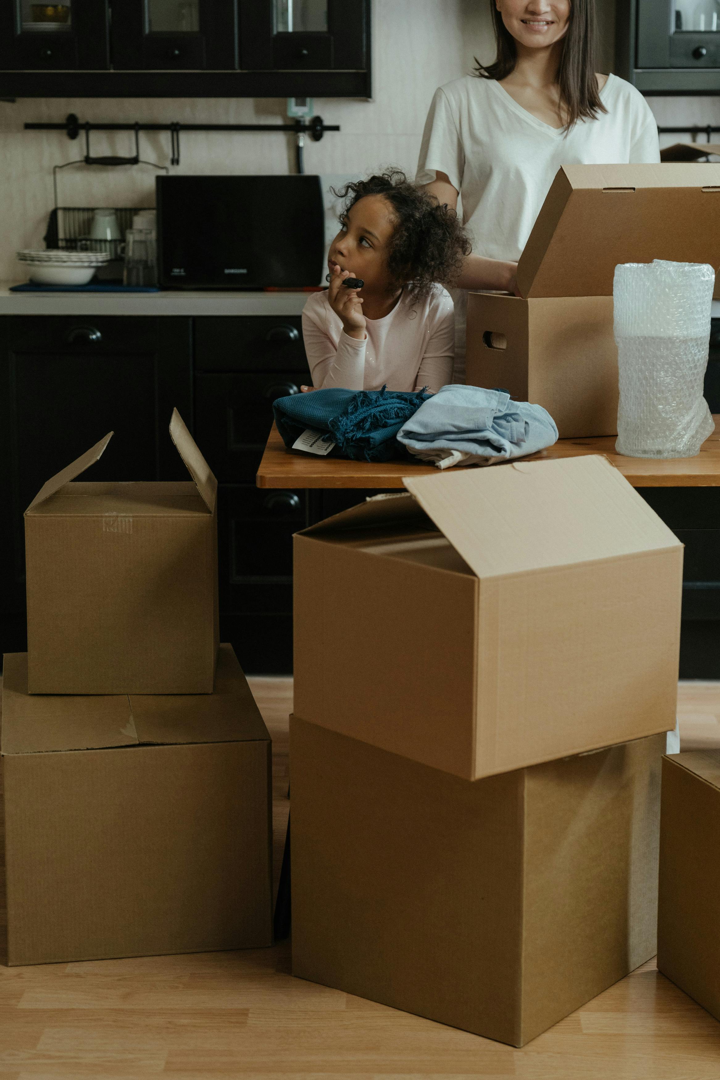 woman in blue long sleeve shirt sitting on brown cardboard box