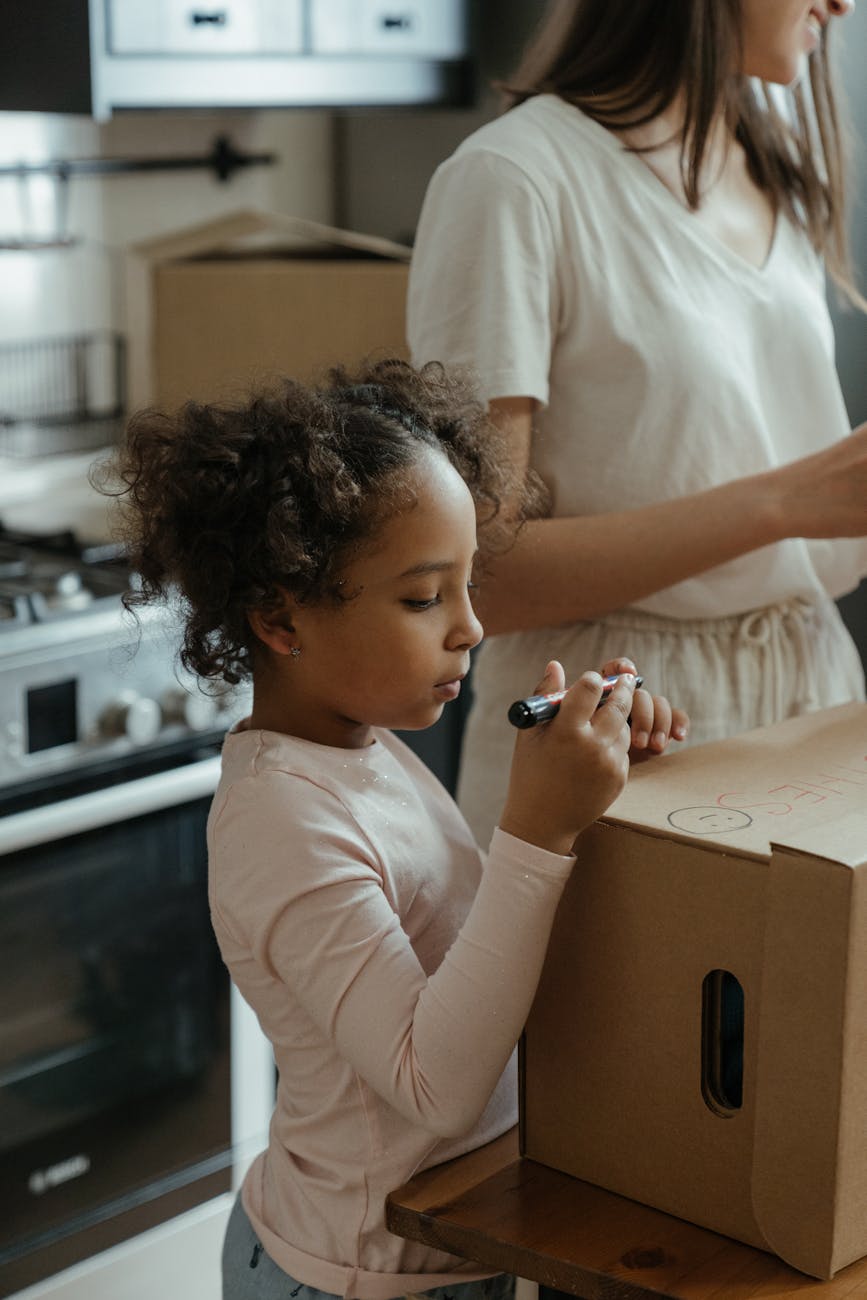 A mother and daughter engage in unpacking activities in their new apartment, enjoying family time together.