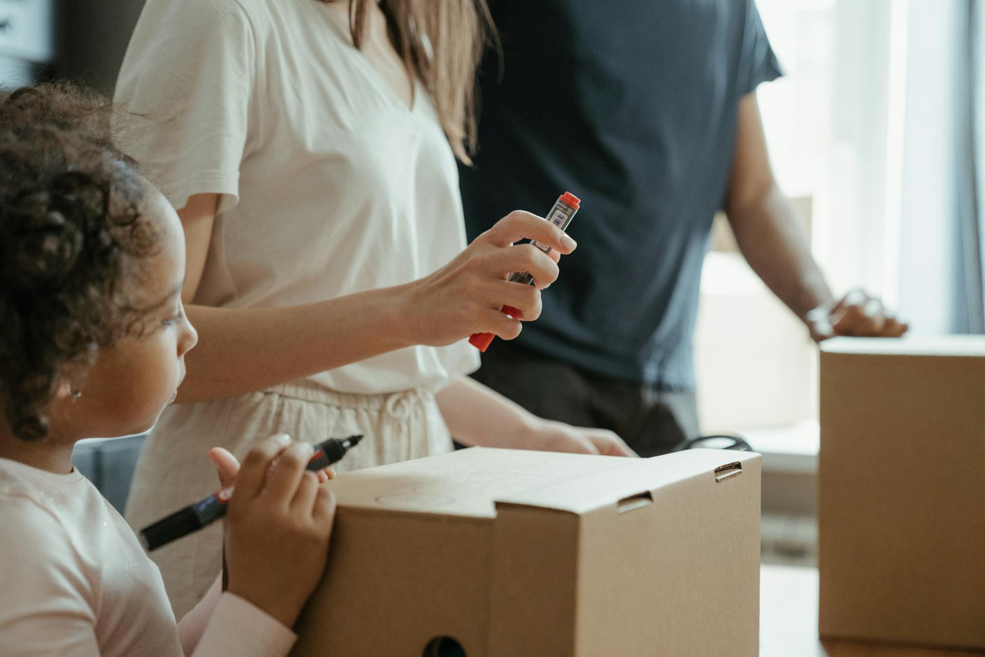 A family engaging in domestic life while moving into a new home, unpacking boxes.